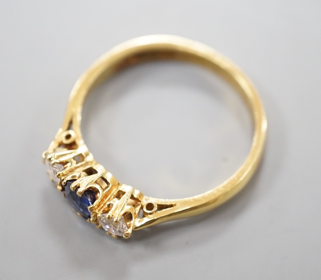 A modern 18ct gold, sapphire and diamond set three stone ring, size S, gross weight 4.4 grams